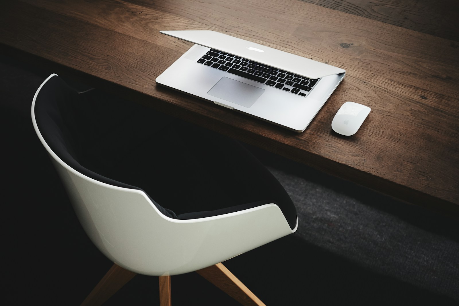 Apple MacBook with end-of-life software beside computer mouse on table